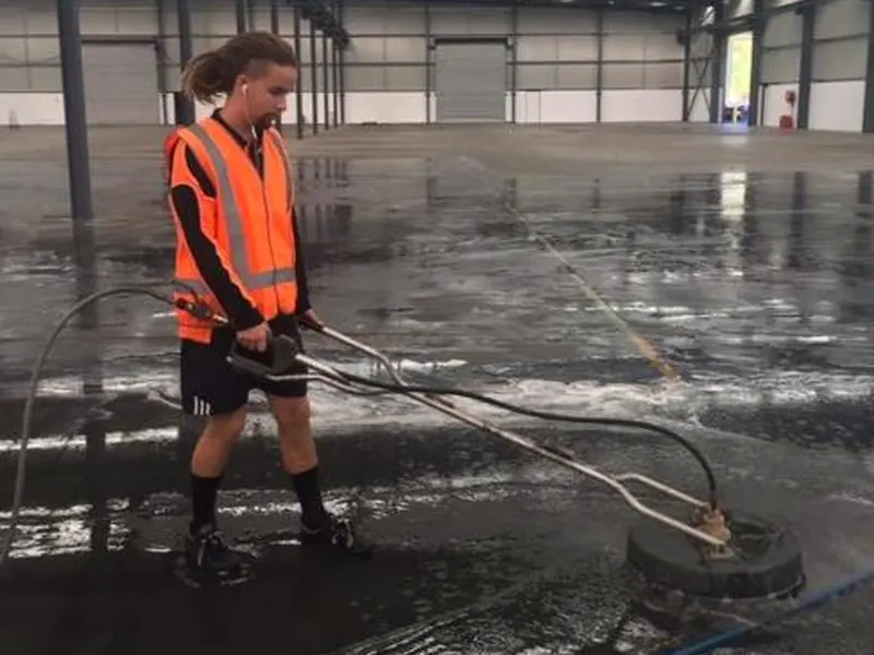 Industrial floor being pressure cleaned with commercial equipment