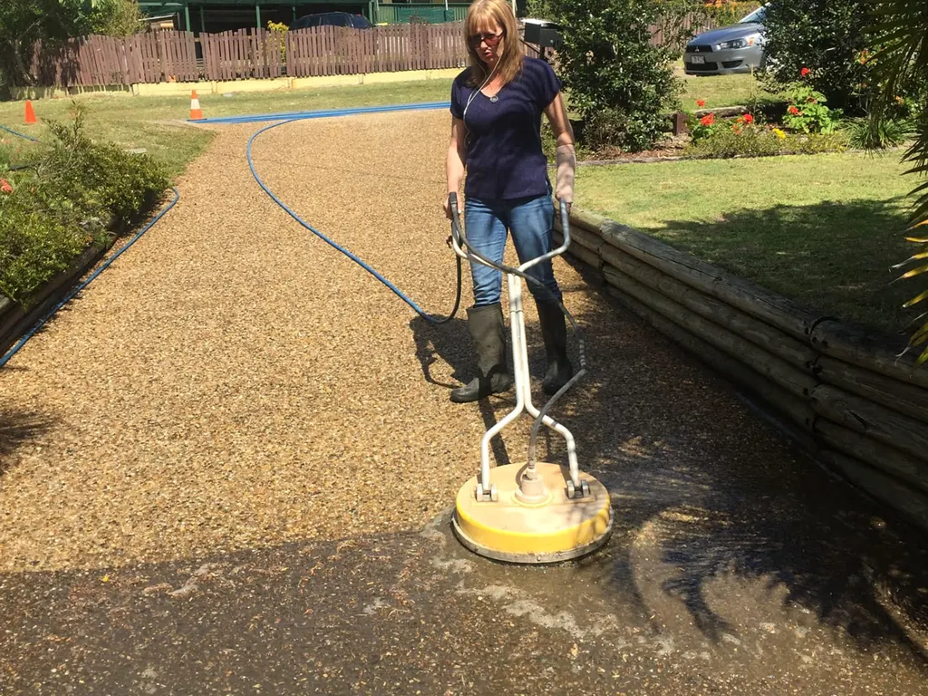 Concrete driveway being pressure cleaned with a surface cleaner